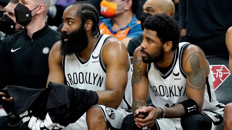 Nets guard James Harden, left, and guard Kyrie Irving watch...