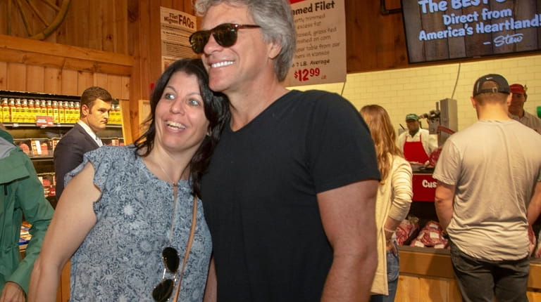 Singer Jon Bon Jovi, poses with shopper Gereese Gambino, of...
