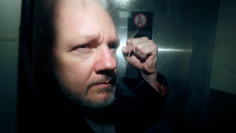 WikiLeaks founder Julian Assange being taken from court, where he...