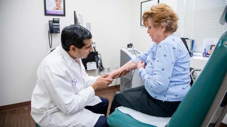 Dr. Raman Madan, a dermatologist in Huntington, examines Sue Martin...