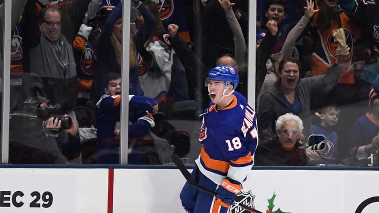 Islanders left wing Anthony Beauvillier and fans celebrate after he...