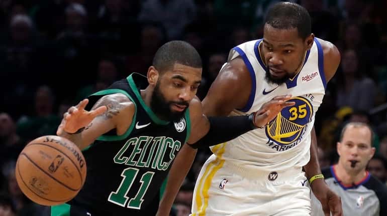 Celtics guard Kyrie Irving  dribbles against Warriors forward Kevin Durant...