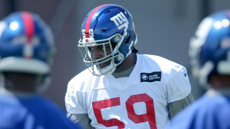 Giants linebacker Lorenzo Carter lines up against the offense during training...