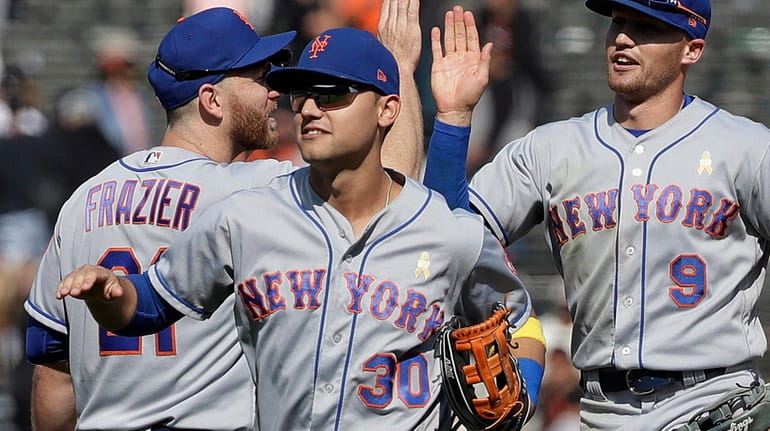Mets' Todd Frazier, left, celebrates with Michael Conforto (30) and...