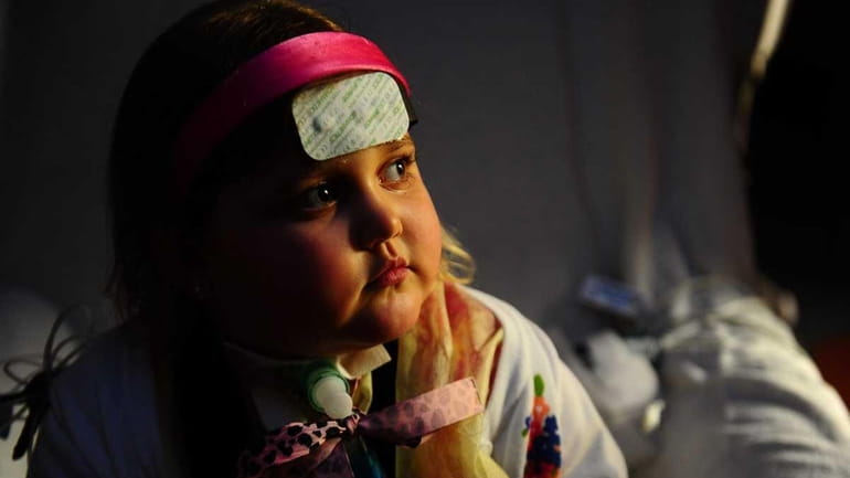 Marisa Carney, 5, sits in a hospital room awaiting a...