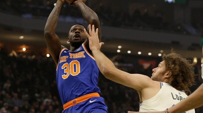 The Knicks' Julius Randle  shoots against the Bucks' Robin Lopez...