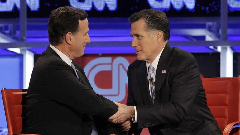 Rick Santorum and Mitt Romney talk following a Republican presidential...