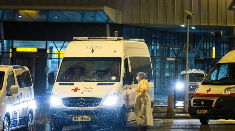  Red Cross health workers transport passengers infected with coronavirus returning...
