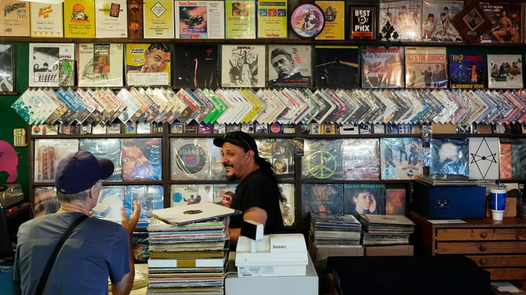 Tim Stamper, right, owner at Tracks In Wax record shop,...