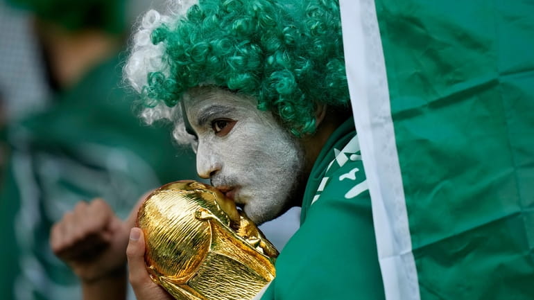 A Saudi Arabia fan kisses a copy of the World...