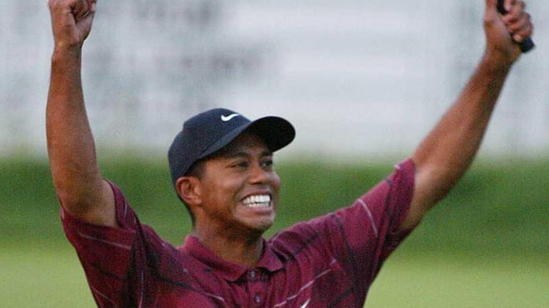 Tiger Woods celebrates his win on the 18th green at...