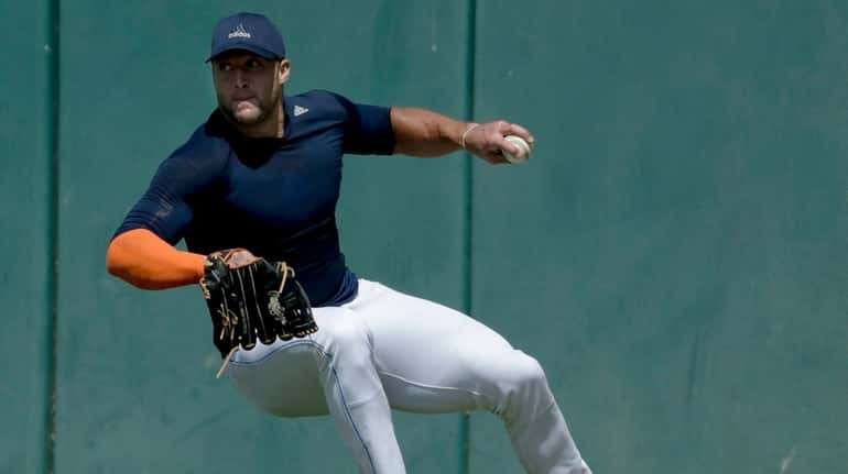 Tim Tebow fields a ball for baseball scouts and the...