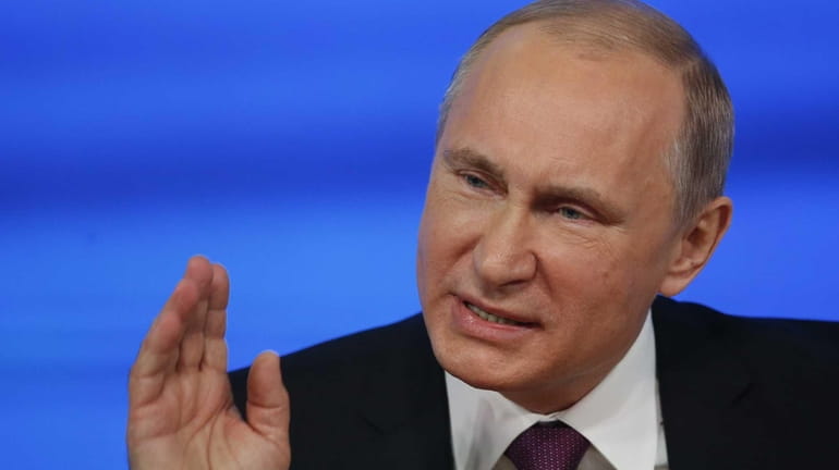Russian President Vladimir Putin gestures during his annual news conference...