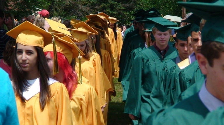 Graduates file into the commencement ceremony at Ward Melville High...