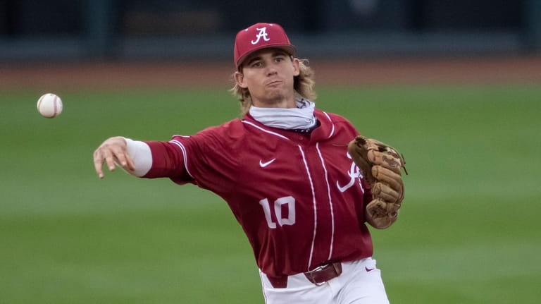 Alabama infielder Jim Jarvis throws to first for the out...