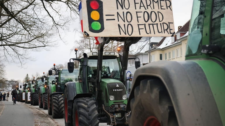 Farmers demonstrate with their tractors in front of the state...