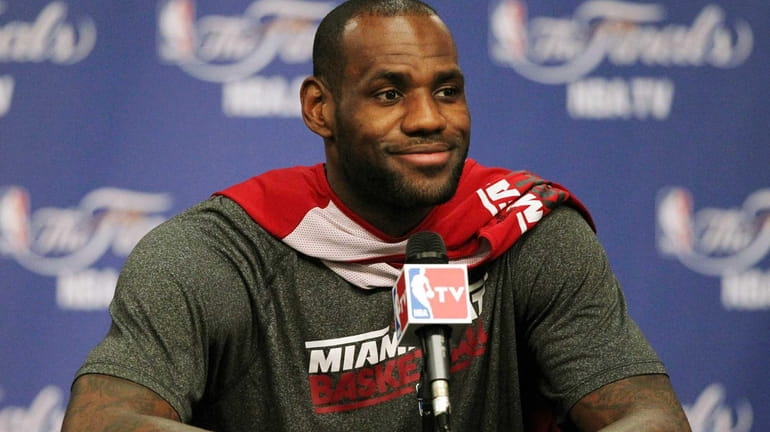 Miami Heat forward LeBron James speaks with reporters before the...