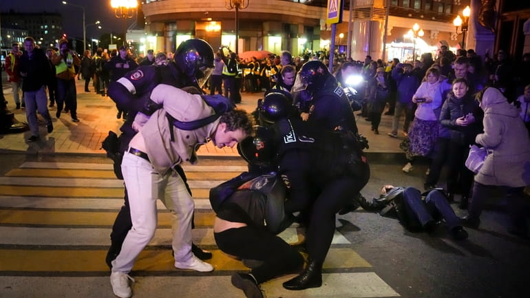 Riot police detain demonstrators during a protest against mobilization in...