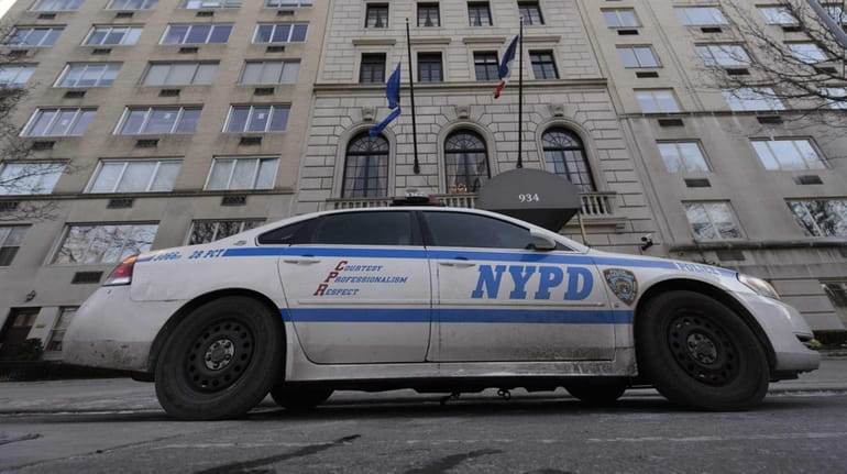 A New York City police car is posted in front...