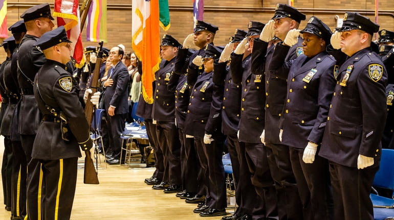 Officers being promoted to detective salute during an NYPD promotion ceremony...