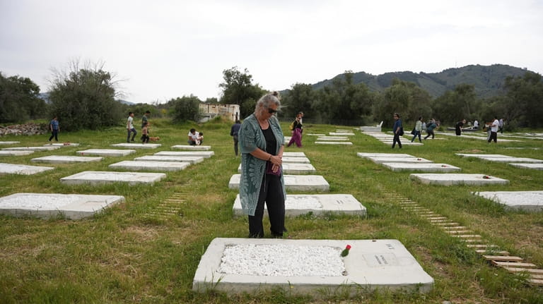 People visit the cemetery at Kato Tritos village on the...