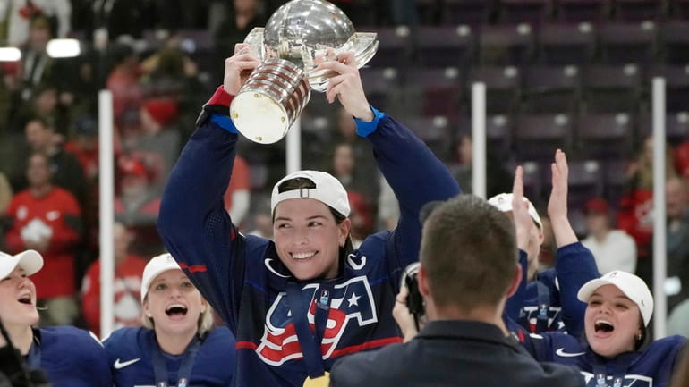 United States forward Hilary Knight (21) holds the cup as...