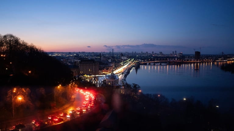 Cars drive along in traffic after heavy rainfall in Kyiv,...