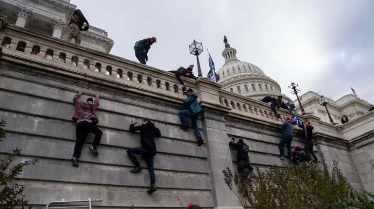 Trump supporters scaled the walls on the Senate side of...