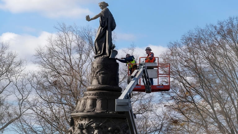 Workers prepare a Confederate Memorial for removal in Arlington National...