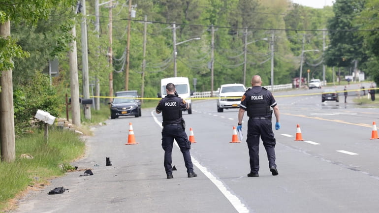 Suffolk County police at the scene Sunday in Holtsville where, authorities...