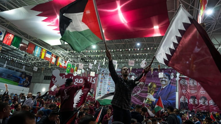FILE - Palestinian soccer fans wave Qatari and Palestinian flags...