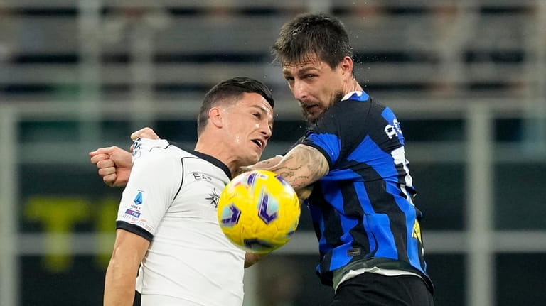 Napoli's Giacomo Raspadori, left, jumps for the ball with Inter...