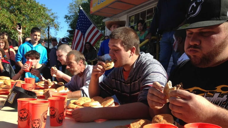 Participants scarf down burgers during a contest at Beach Burger...
