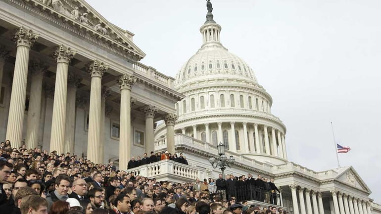Members of Congress and staff members gather to observe a...
