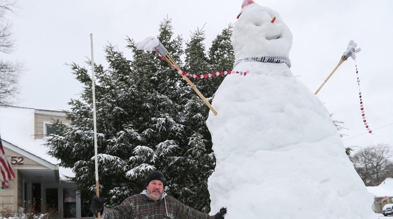 Mike Fregoe stands beside a snowman, over 14-feet tall, in...