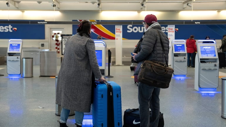 Passengers use a Southwest Airlines kiosk as travel returns to...