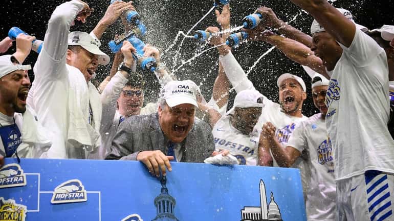 Hofstra coach Joe Mihalich is showered with water from his...