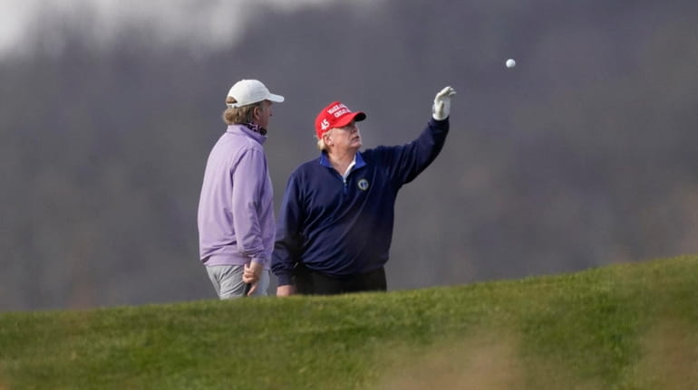 President Donald Trump is tossed a golf ball Sunday at...