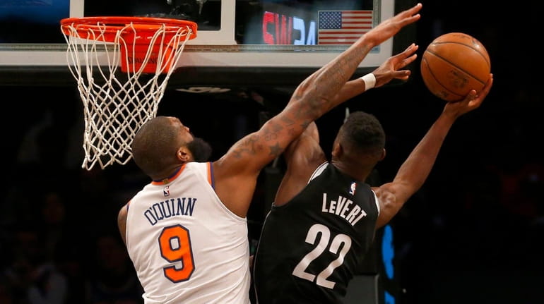Knicks center Kyle O'Quinn defends against Nets guard Caris LeVert...