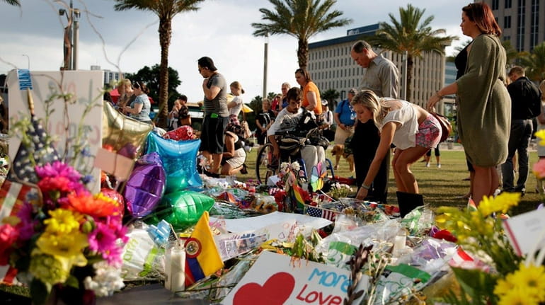 People visit the makeshift memorial for the victims of the...