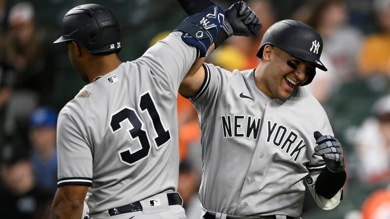 The Yankees' Jose Trevino, right, celebrates his three-run home run...