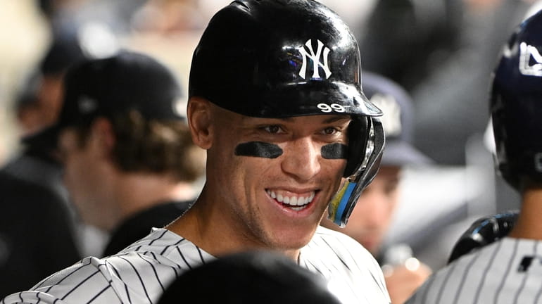 New York Yankees' Aaron Judge smiles in the dugout after...
