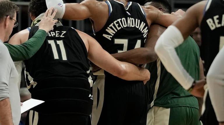 Milwaukee Bucks' Giannis Antetokounmpo is helped off the court during...