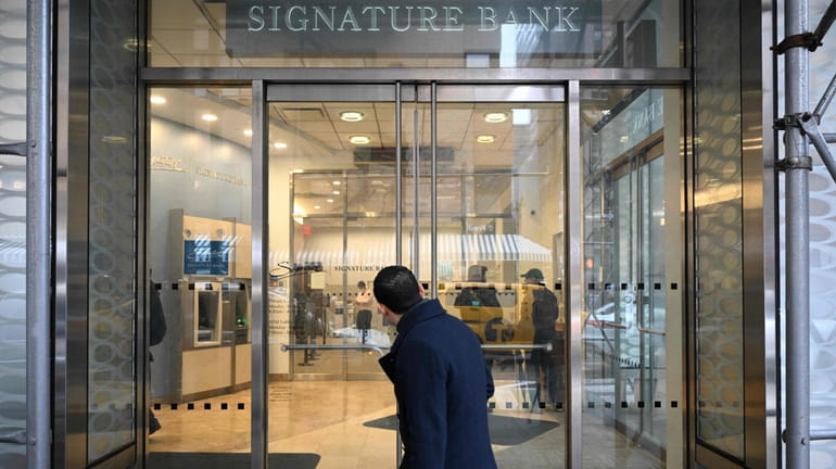 A man walks past a branch of Signature Bank in...