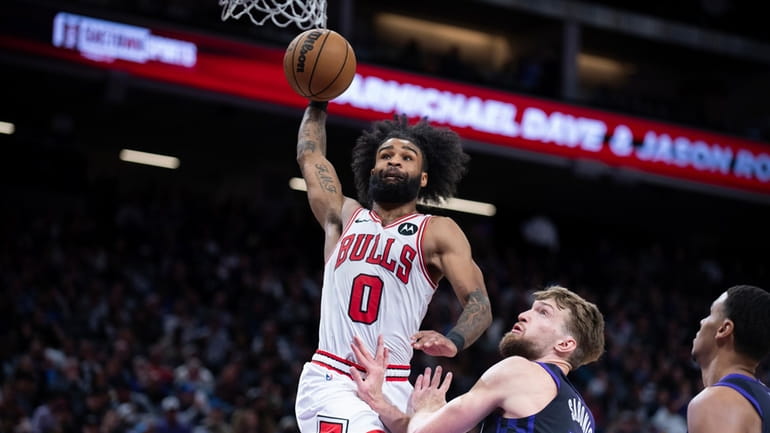 Chicago Bulls guard Coby White (0) scores a basket over...