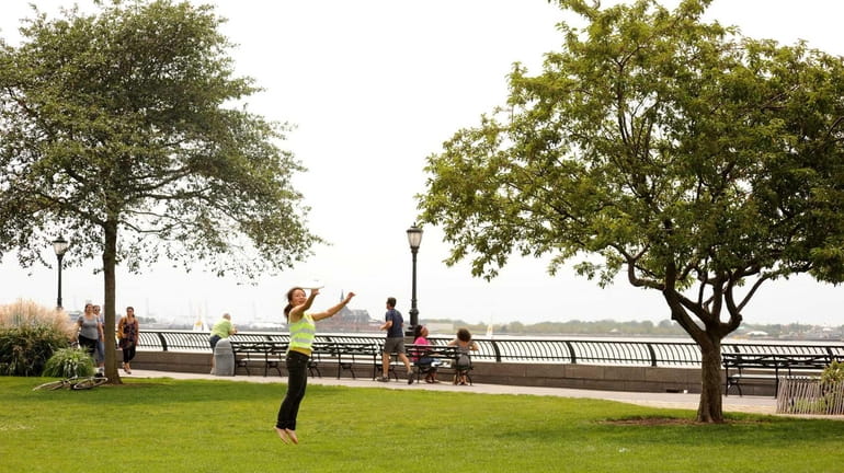 Kathy Tin of Brooklyn plays Frisbee in the Esplanade. (Aug....