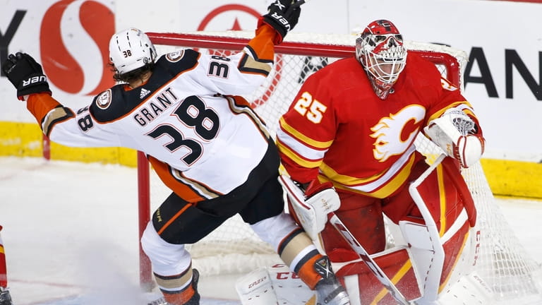 Anaheim Ducks' Derek Grant (38) runs into Calgary Flames goalie...