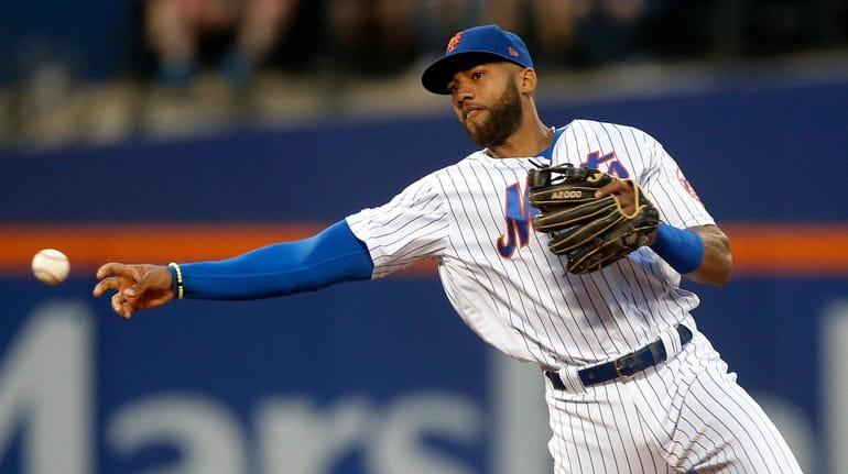 Amed Rosario #1 of the New York Mets throws for...