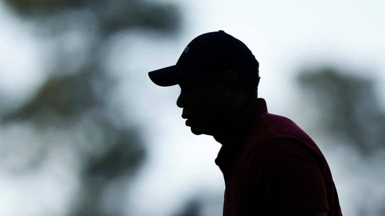 Tiger Woods walks to the tee on the fourth hole...