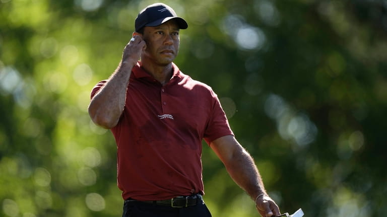 Tiger Woods walks to the green on the fifth hole...